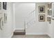 Carpeted staircase with white wood bannister and neutral walls decorated with an array of framed photographs at 6219 S Krameria St, Centennial, CO 80111