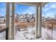 View from porch, showcasing a row of colorful townhomes with fenced yards and snowy landscaping at 6211 W 28Th Ct, Wheat Ridge, CO 80214