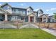 Well-maintained townhouse complex with blue siding, white trim, red doors, and shared grassy lawn and walkway at 6211 W 28Th Ct, Wheat Ridge, CO 80214