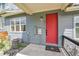 Exterior view of a gray home with a red front door, utility connections, and minimal landscaping at 6211 W 28Th Ct, Wheat Ridge, CO 80214
