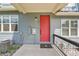 Exterior view of a gray home with a red front door, utility connections, and minimal landscaping at 6211 W 28Th Ct, Wheat Ridge, CO 80214
