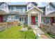 Charming townhome featuring a red front door, covered porch, and small front yard with wooden fence at 6211 W 28Th Ct, Wheat Ridge, CO 80214