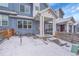 View of the front porch and yard of a modern blue home in the winter at 6211 W 28Th Ct, Wheat Ridge, CO 80214