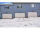 Garage and driveway view of three modern townhomes in a neighborhood at 6211 W 28Th Ct, Wheat Ridge, CO 80214