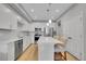Well-lit kitchen boasts stainless steel appliances, white cabinetry, quartz countertop island, and barstool seating at 6211 W 28Th Ct, Wheat Ridge, CO 80214