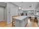 Open-concept layout with an island and seating that seamlessly connects the kitchen to the living area and staircase at 6211 W 28Th Ct, Wheat Ridge, CO 80214
