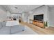 Bright open-concept living room featuring hardwood floors, a modern kitchen, and a comfortable sectional sofa at 6211 W 28Th Ct, Wheat Ridge, CO 80214
