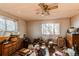 A cluttered bedroom featuring a ceiling fan and two windows is ready for renovation at 18199 E 160Th Ave, Brighton, CO 80601