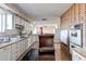 Spacious kitchen with white cabinets, tile floors and backsplash, and brick accent wall at 18199 E 160Th Ave, Brighton, CO 80601