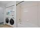 Bright bathroom and laundry room combination with washer and dryer next to shower tub at 23451 E 5Th Dr # 203, Aurora, CO 80018