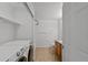Well-lit utility room with washer, dryer, storage shelves, and access to the main bathroom at 23451 E 5Th Dr # 203, Aurora, CO 80018