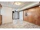 Unfinished basement area with wood paneling, drop ceiling, and tile flooring; ideal for storage and utilities at 13086 E Alaska Ave, Aurora, CO 80012