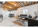 Unfinished basement with exposed ceiling, cozy furniture, and a large window for natural light at 13220 E 110Th Pl, Commerce City, CO 80022