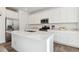 Bright kitchen featuring white cabinets, a quartz countertop island, and stainless steel appliances at 13220 E 110Th Pl, Commerce City, CO 80022