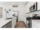 Stylish kitchen with stainless steel appliances, white cabinets, and hardwood floors at 13220 E 110Th Pl, Commerce City, CO 80022