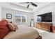 Bright main bedroom with a tray ceiling, comfortable bed, and large windows overlooking the neighborhood at 13220 E 110Th Pl, Commerce City, CO 80022