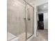 Glass enclosed shower with tiled surround and an open doorway to the walk-in closet at 13220 E 110Th Pl, Commerce City, CO 80022