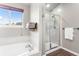 Bright bathroom featuring a soaking tub and glass enclosed shower with tiled walls at 19064 E Oak Creek Way, Parker, CO 80134