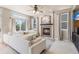 Bright living room with fireplace, plush seating, and access to the outdoors at 19064 E Oak Creek Way, Parker, CO 80134