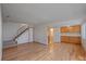 Bright living room featuring gleaming hardwood floors, stairs, and convenient built-in cabinets at 9255 E Lehigh Ave # 194, Denver, CO 80237