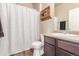 Well-lit bathroom featuring a shower with patterned curtain, single sink vanity, and a decorative wall shelf at 5758 Echo Park Cir, Castle Rock, CO 80104