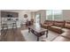 Open concept living and dining area with hardwood floors, large sectional, and modern decor at 5758 Echo Park Cir, Castle Rock, CO 80104
