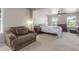 Spacious main bedroom featuring natural light, plush carpet, an upholstered chair, and a ceiling fan at 5758 Echo Park Cir, Castle Rock, CO 80104