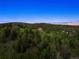 Expansive aerial view of the property surrounded by mountain scenery and lush foliage at 28532 Hummingbird Hill Rd, Conifer, CO 80433