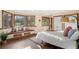 Bright bedroom with window seat, hardwood floors, and multiple windows showing wooded area at 28532 Hummingbird Hill Rd, Conifer, CO 80433