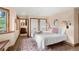 Cozy bedroom with hardwood floors, white trim, and an attached bathroom with a decorative rug at 28532 Hummingbird Hill Rd, Conifer, CO 80433