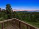 Relaxing deck overlooking a serene mountain landscape at twilight at 28532 Hummingbird Hill Rd, Conifer, CO 80433