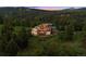 Stunning mountain home with expansive windows and lush greenery at 28532 Hummingbird Hill Rd, Conifer, CO 80433