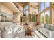 Bright living room features a neutral palette, walls of windows with stunning outdoor views, and stone accents at 28532 Hummingbird Hill Rd, Conifer, CO 80433