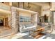 Bright living room features a neutral palette, walls of windows with stunning outdoor views, and stone accents at 28532 Hummingbird Hill Rd, Conifer, CO 80433