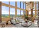 Inviting living room featuring large windows with mountain views and stone accent columns at 28532 Hummingbird Hill Rd, Conifer, CO 80433