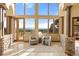 Bright sitting room features a neutral palette, walls of windows with stunning outdoor views, and stone accents at 28532 Hummingbird Hill Rd, Conifer, CO 80433