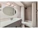 Updated bathroom with a gray vanity, oval mirror, modern lighting, and a shower-tub combination at 9300 E Center Ave # 3A, Denver, CO 80247