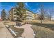 Exterior view of a well maintained apartment building with grassy areas, benches, and a sidewalk at 9300 E Center Ave # 3A, Denver, CO 80247