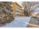 Three-story tan apartment building featuring balconies with decorative concrete screens, and a snow covered lawn at 9300 E Center Ave # 3A, Denver, CO 80247