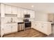 Bright kitchen with white cabinets, stainless steel appliances, stone countertops, and wood flooring at 9300 E Center Ave # 3A, Denver, CO 80247