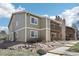 A charming condominium featuring light green siding, stone chimney, and a private balcony at 3450 S Eagle St # 101, Aurora, CO 80014