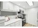 Well-lit kitchen with white cabinets, modern hardware, and stainless steel appliances at 3450 S Eagle St # 101, Aurora, CO 80014