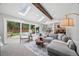 Open-concept living room with large sliding glass doors to a deck, skylights, and seamless flow to the kitchen at 5991 S Eudora Way, Centennial, CO 80121