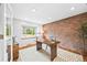 Home office featuring a brick accent wall, hardwood floors, and a light-filled window at 5991 S Eudora Way, Centennial, CO 80121
