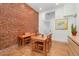 Cozy dining room featuring exposed brick, a wooden table set, and natural light at 1435 Lipan St, Denver, CO 80204