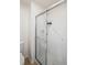 Bathroom shower with glass doors and white tile, complete with safety bars and built-in shelving at 9765 Merimbula St, Highlands Ranch, CO 80130