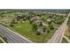 Lovely aerial view of a charming home with verdant green lawn, pond, mature trees, and surrounding neighborhood at 7930 Alkire St, Arvada, CO 80005