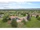 Expansive aerial view of a charming blue home with lush green lawn, mature trees, and circular driveway at 7930 Alkire St, Arvada, CO 80005