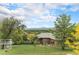 Fenced backyard with lawn, mature trees, and view of the surrounding landscape at 7930 Alkire St, Arvada, CO 80005