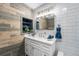 Stylish bathroom featuring wood accent wall, built in linen closet, and modern fixtures at 7930 Alkire St, Arvada, CO 80005